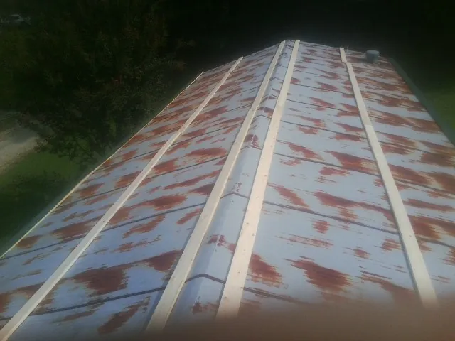 Rusted metal roof panels with new wood purlins before replacement — Storm Damage Roof Repair in Francestown by Roofing Brothers
